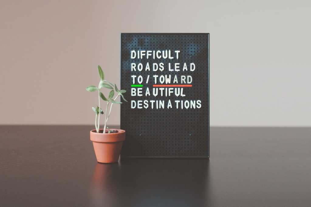 A letter board with an example of confusing prepositions: Difficult roads lead to/toward beautiful destinations,