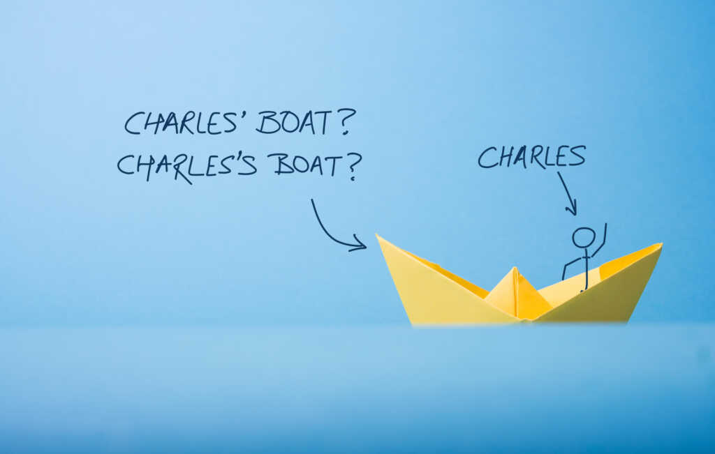 A picture of a yellow paper boat against a blue background. A stick figure stands in the boat, waving at you. An annotation shows that this is Charles. Another annotation asks the question: Is it "Charles' boat" or "Charles's boat"?